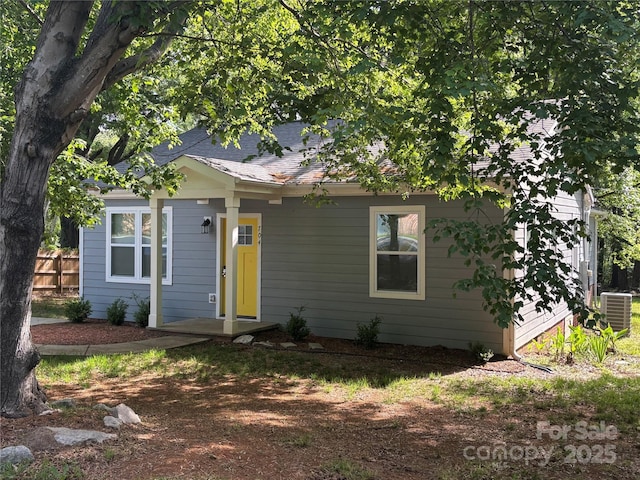 view of front of property with fence and central AC unit