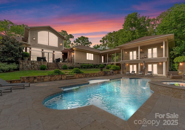 2915 Cutter Ct, Waxhaw, NC 28173 - pool at dusk with french doors, a patio, stairs, and a pool with connected hot tub
