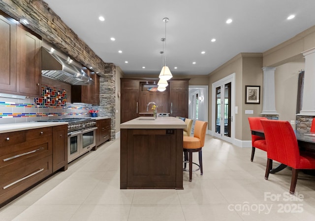 2915 Cutter Ct, Waxhaw, NC 28173 - kitchen with range with two ovens, backsplash, light countertops, recessed lighting, and an island with sink