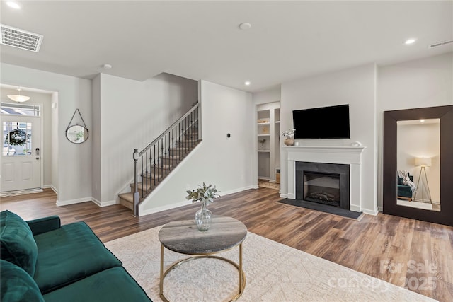 15622 Little Bluestem St, Charlotte, NC 28278 - living area with wood finished floors, stairs, baseboards, recessed lighting, and a glass covered fireplace