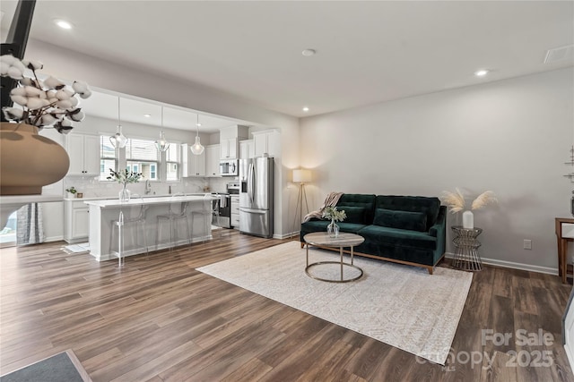 15622 Little Bluestem St, Charlotte, NC 28278 - living area with dark wood finished floors, recessed lighting, and baseboards
