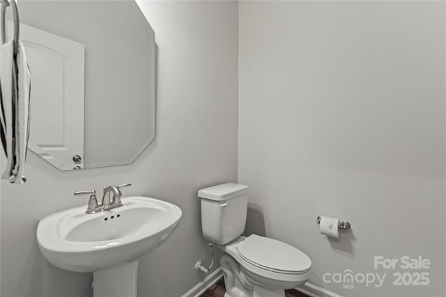 15622 Little Bluestem St, Charlotte, NC 28278 - half bath featuring toilet, baseboards, a sink, and wood finished floors