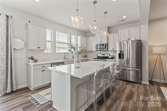 15622 Little Bluestem St, Charlotte, NC 28278 - kitchen featuring stainless steel appliances, dark wood-style flooring, white cabinets, a sink, and light countertops