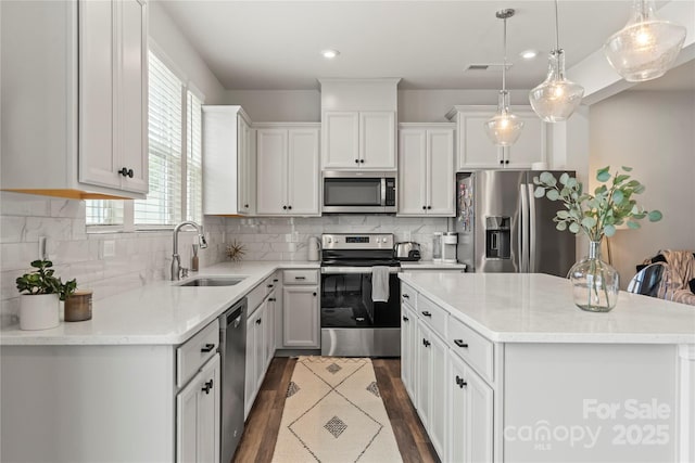 15622 Little Bluestem St, Charlotte, NC 28278 - kitchen featuring appliances with stainless steel finishes, a sink, a kitchen island, decorative light fixtures, and recessed lighting