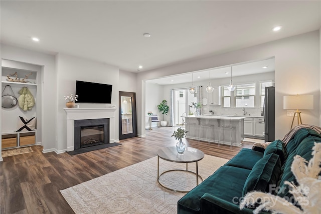 15622 Little Bluestem St, Charlotte, NC 28278 - living room featuring recessed lighting, dark wood-style floors, a fireplace with flush hearth, and baseboards