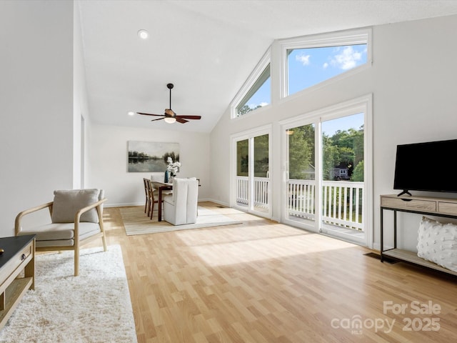living area featuring visible vents, high vaulted ceiling, wood finished floors, and a ceiling fan