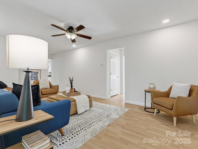 living room featuring baseboards, recessed lighting, wood finished floors, and a ceiling fan