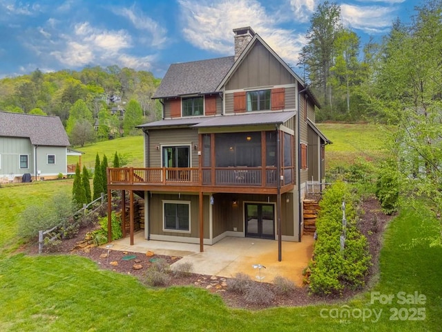 rear view of property with a chimney, a lawn, a deck, a patio, and stairs