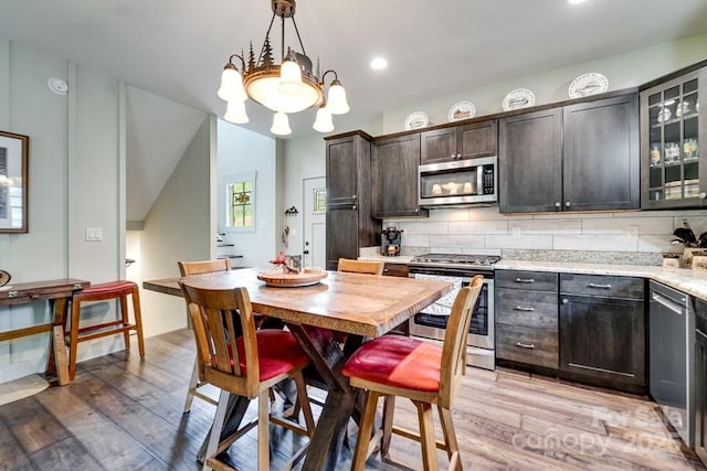 dining area featuring light wood-type flooring, recessed lighting, and a notable chandelier