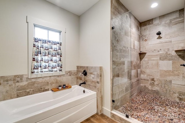 bathroom with a garden tub, recessed lighting, wood finished floors, and a shower stall