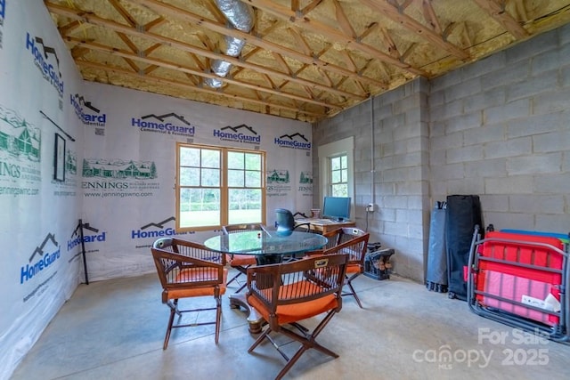 dining room with concrete flooring and high vaulted ceiling