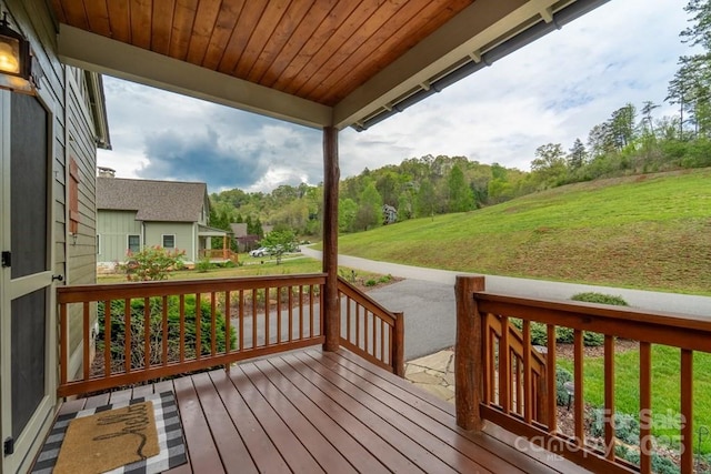 wooden deck with a yard and covered porch