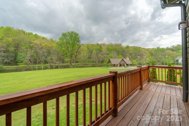 wooden deck featuring a yard and a view of trees