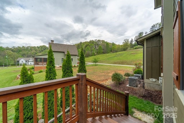 wooden deck featuring a lawn and central AC