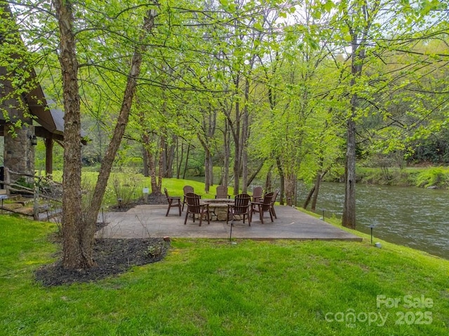 view of yard with a water view, a patio area, and an outdoor fire pit