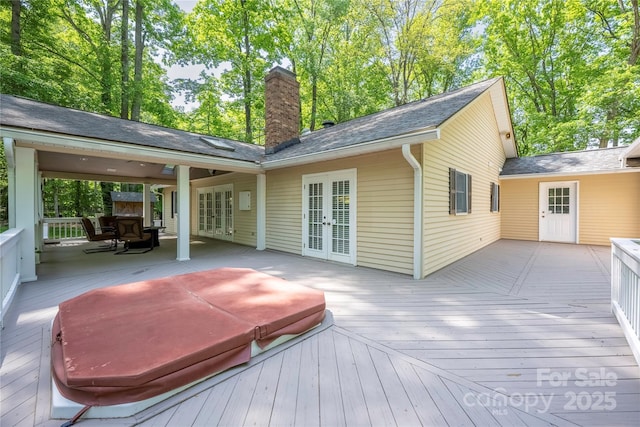 wooden deck featuring a covered hot tub and french doors