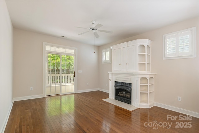 unfurnished living room with baseboards, a fireplace with flush hearth, a ceiling fan, and hardwood / wood-style flooring
