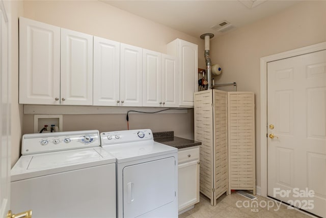 laundry area featuring cabinet space, visible vents, light tile patterned floors, and washing machine and clothes dryer