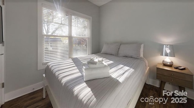 bedroom with baseboards and wood finished floors
