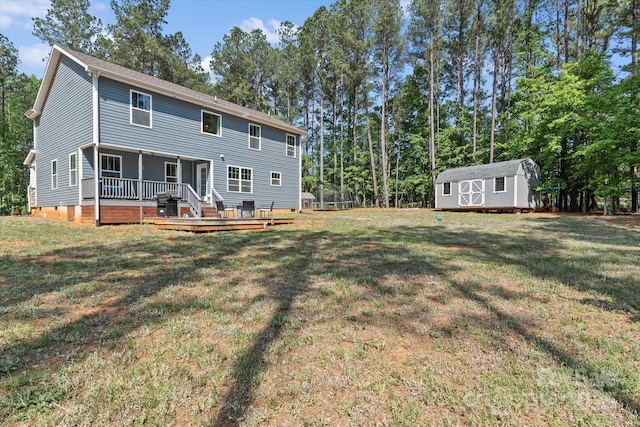 rear view of house featuring a yard, an outbuilding, a shed, and a wooden deck