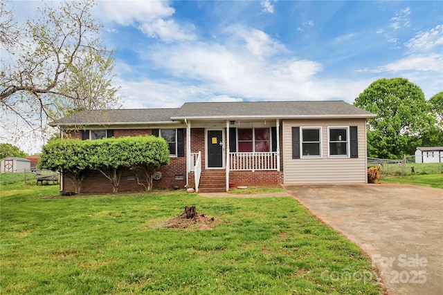 ranch-style house with a porch, a front yard, brick siding, and fence