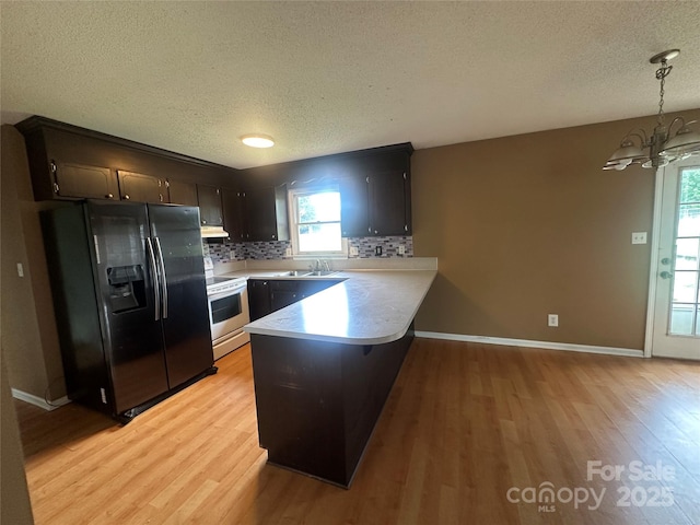 kitchen featuring a textured ceiling, black refrigerator with ice dispenser, white electric stove, and a peninsula