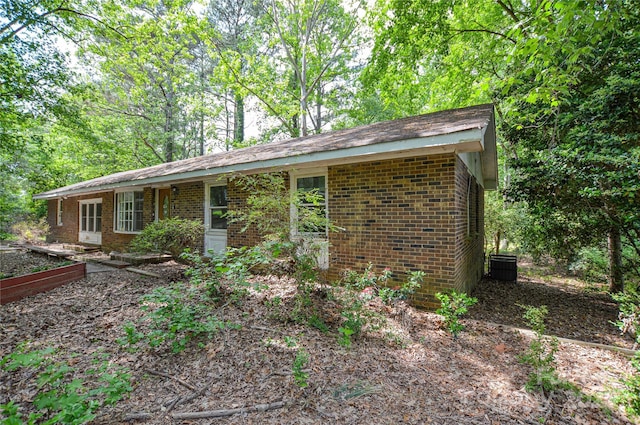 view of front of house featuring brick siding and central AC unit