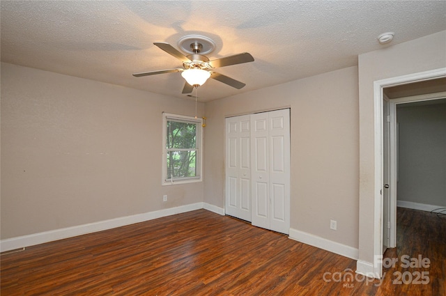 unfurnished bedroom with a ceiling fan, a closet, a textured ceiling, baseboards, and wood finished floors