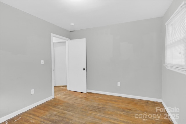 empty room featuring baseboards and wood finished floors
