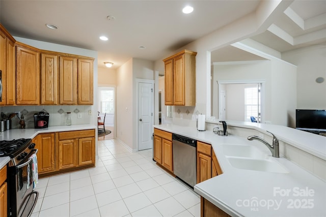 kitchen with plenty of natural light, a sink, appliances with stainless steel finishes, and light countertops