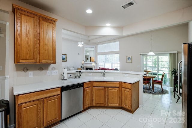kitchen with visible vents, a peninsula, brown cabinets, and stainless steel appliances