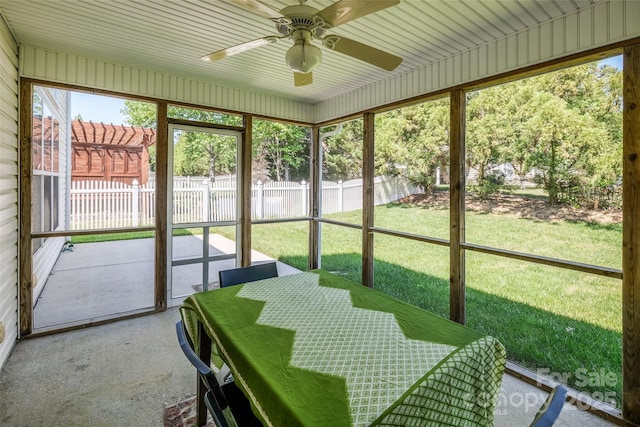 sunroom with a ceiling fan and outdoor dining area
