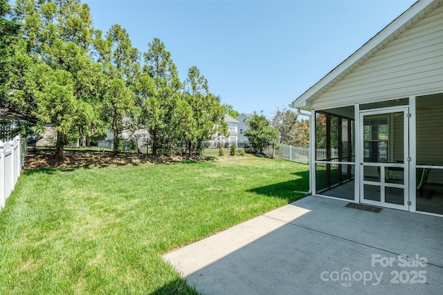 view of yard featuring a sunroom, a fenced backyard, and a patio area