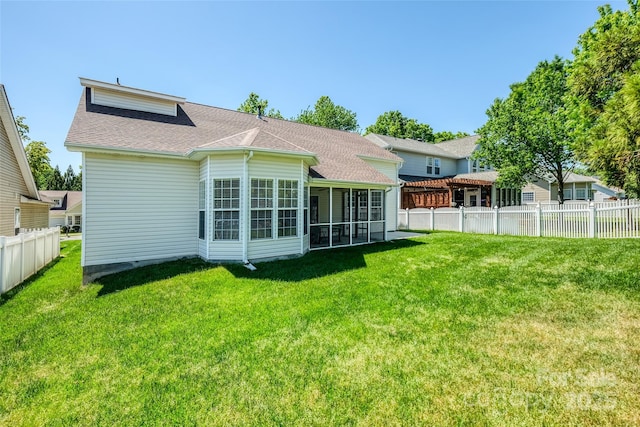 back of property with a yard, fence, and a sunroom