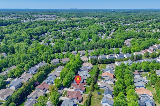 birds eye view of property featuring a residential view and a wooded view
