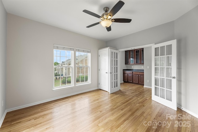 2151 Belle Vernon Ave, Charlotte, NC 28210 - unfurnished living room with french doors, light wood-style flooring, baseboards, and a ceiling fan