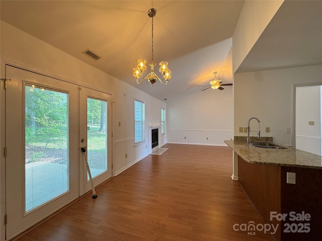 interior space featuring dark wood-type flooring, visible vents, lofted ceiling, and a sink
