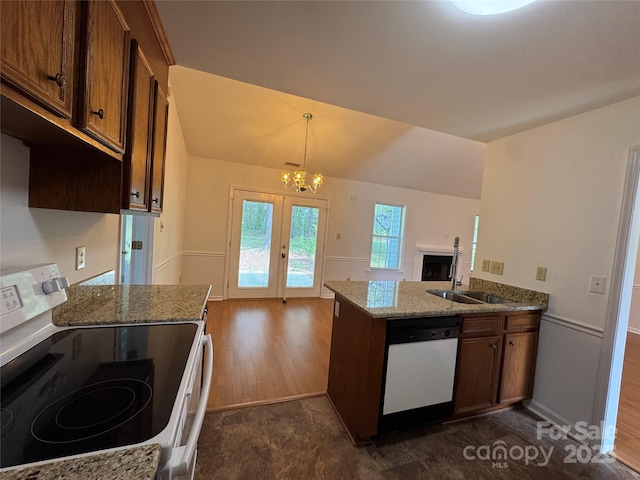 kitchen featuring a chandelier, dark wood finished floors, stone counters, french doors, and white appliances