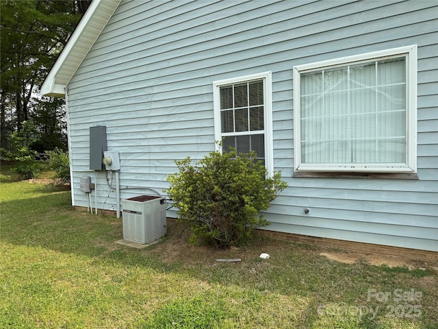 view of home's exterior with a yard and central AC