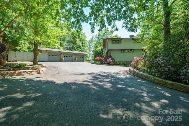 view of side of property featuring a garage and aphalt driveway