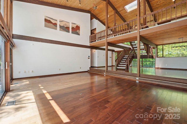 unfurnished living room with high vaulted ceiling, wood finished floors, visible vents, wood ceiling, and stairway