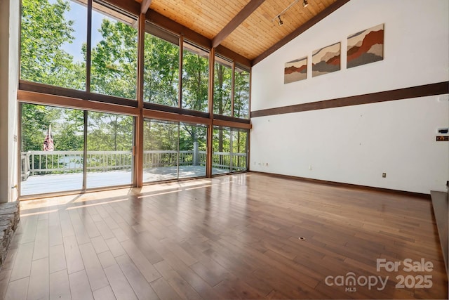 unfurnished living room featuring wood finished floors, beamed ceiling, baseboards, high vaulted ceiling, and wooden ceiling