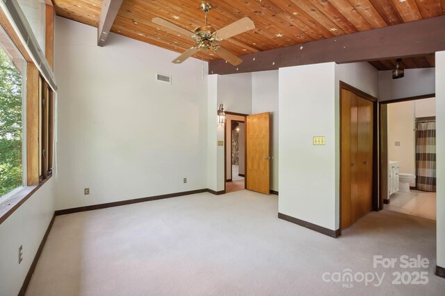 unfurnished bedroom with baseboards, light carpet, wood ceiling, and beam ceiling
