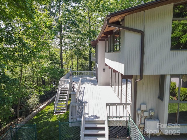 exterior space with fence, a wooden deck, and stairs
