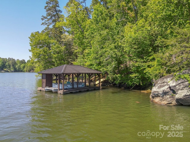 view of dock featuring a water view and a wooded view
