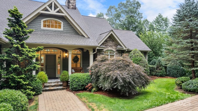 206 Stone Valley Way Unit 23, Hendersonville, NC 28792 - craftsman-style home featuring a chimney, a shingled roof, stone siding, and a front yard