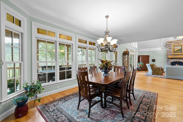 206 Stone Valley Way Unit 23, Hendersonville, NC 28792 - dining space featuring a chandelier, a fireplace, wood finished floors, ornamental molding, and baseboards