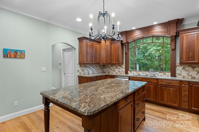 206 Stone Valley Way Unit 23, Hendersonville, NC 28792 - kitchen featuring a sink, light wood-type flooring, arched walkways, decorative backsplash, and dark stone countertops