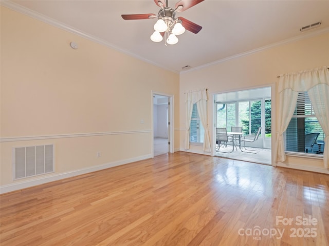 spare room featuring visible vents, a ceiling fan, light wood finished floors, and crown molding