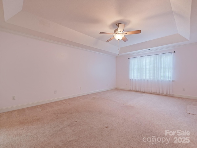 spare room featuring carpet floors, ceiling fan, and a tray ceiling